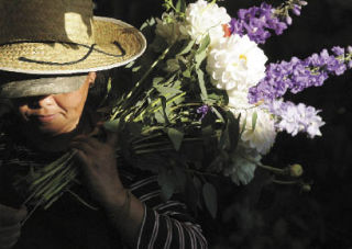 A vendor from Chae Gardens farm bundles flowers Tuesday evening at the Renton Farmers Market at the Piazza.