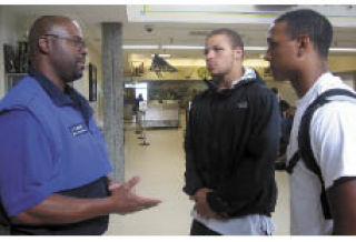 Washington State School Security Officer of the Year Dave Fowler of Kentridge High School talks with Devin Topps and Alex Ferguson during lunch. Topps and Ferguson are both members of the football team and the Kingsmen.