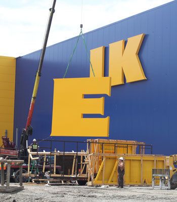 Workers  install the new sign on the iconic blue wall of the new IKEA store being built on Southwest 41st Street.