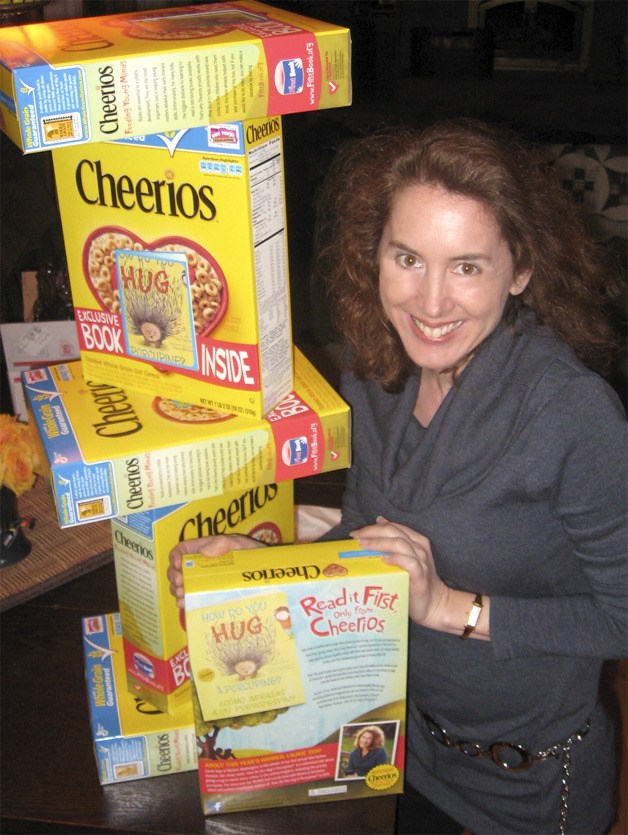 Laurie Isop is surrounded by Cheerios boxes with her children’s book