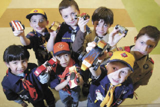 Scouts show their Pinewood Derby race cars Tuesday evening at Benson Hill Elementary. Pictured are (back row
