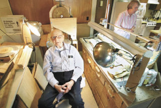 John Hamilton sits in the middle of his homemade woodworking shop