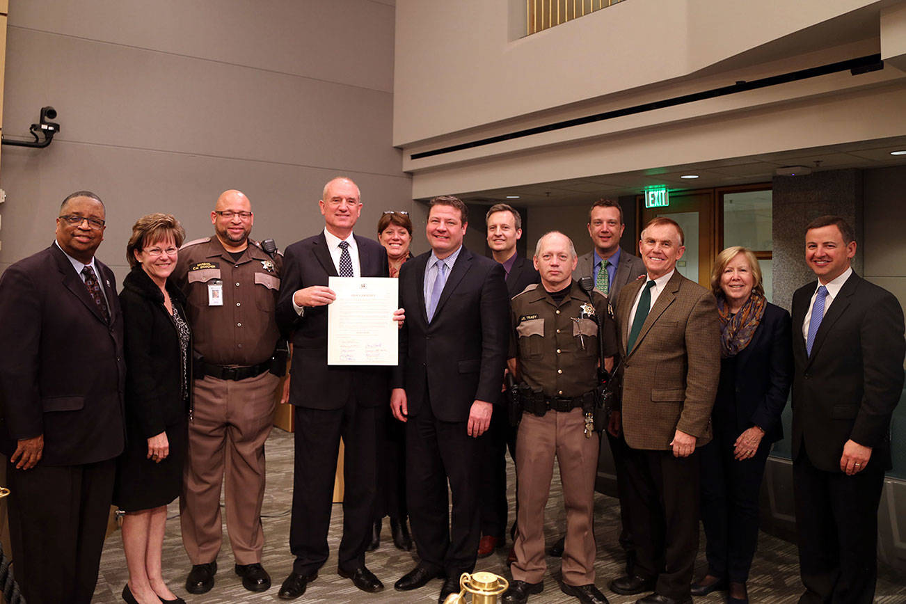 Joined by two Sheriff Deputies, the County Council and King County Sheriff John Urquhart declare the week of May 14-20 Police Week in King County.