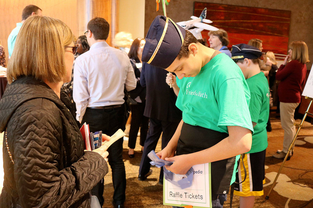 A child distributes raffle tickets to a Celebration of Youth luncheon attendee. Raechel Dawson/staff photo