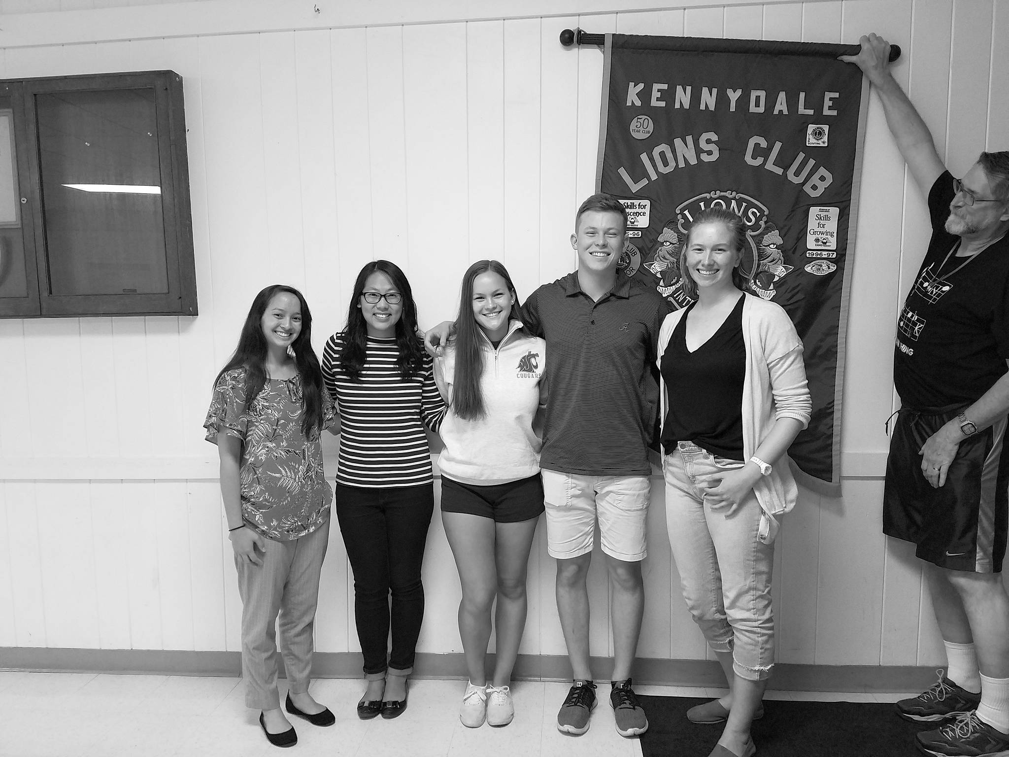 Courtesy photo                                Past winners return yearly to visit the club and to collect their yearly scholarship checks. From the left is Amy Chin (Snyder scholarship), Andressa Chan (Fiene scholarship) , Emma Mason (Purcell scholarship), Michael Mason (Fiene scholarship) and Shelby Mathison (Fiene scholarship). Also pictured is Lion Dave Schott holding the banner.