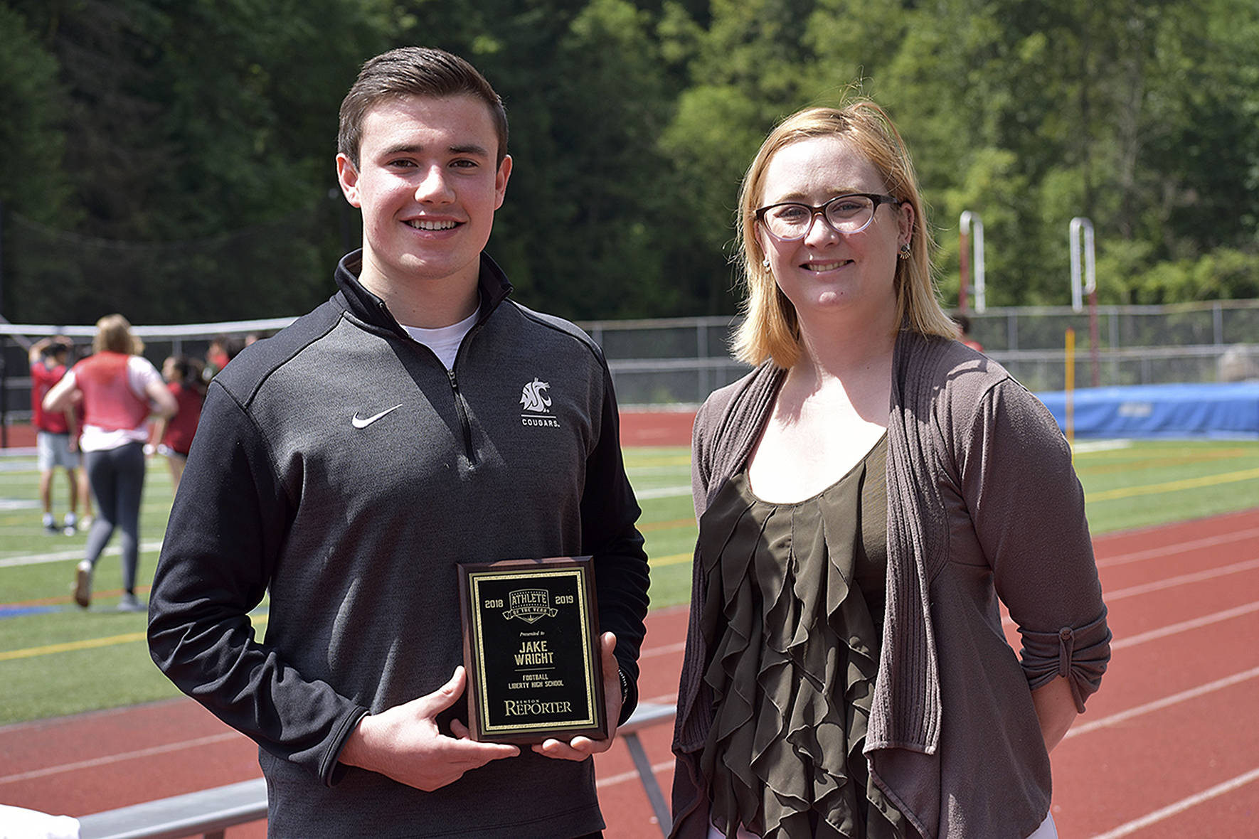 The first ever Male Athlete of the Year for the Renton Reporter went to Jake Wright, left. He was awarded a plaque by Renton Reporter editor Danielle Chastaine (right).                                Photo by Haley Ausbun