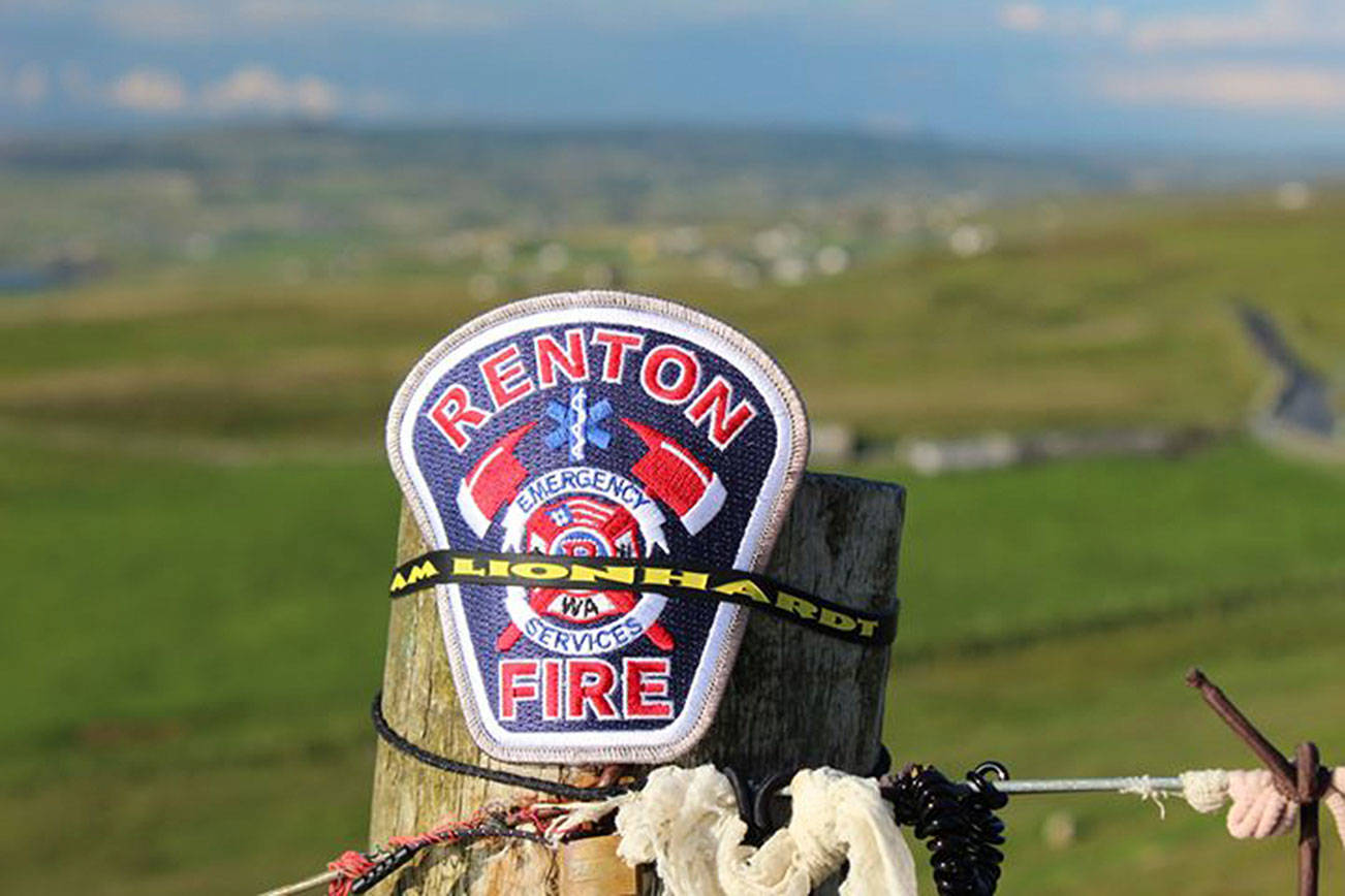 Courtesy of Renton Regional Fire Authority. A fence alongside the coastline and emerald green fields of Cliffs of Moher in Ireland sits a Renton RFA patch, honoring a fallen firefighter who’s legacy inspired a local nonprofit.
