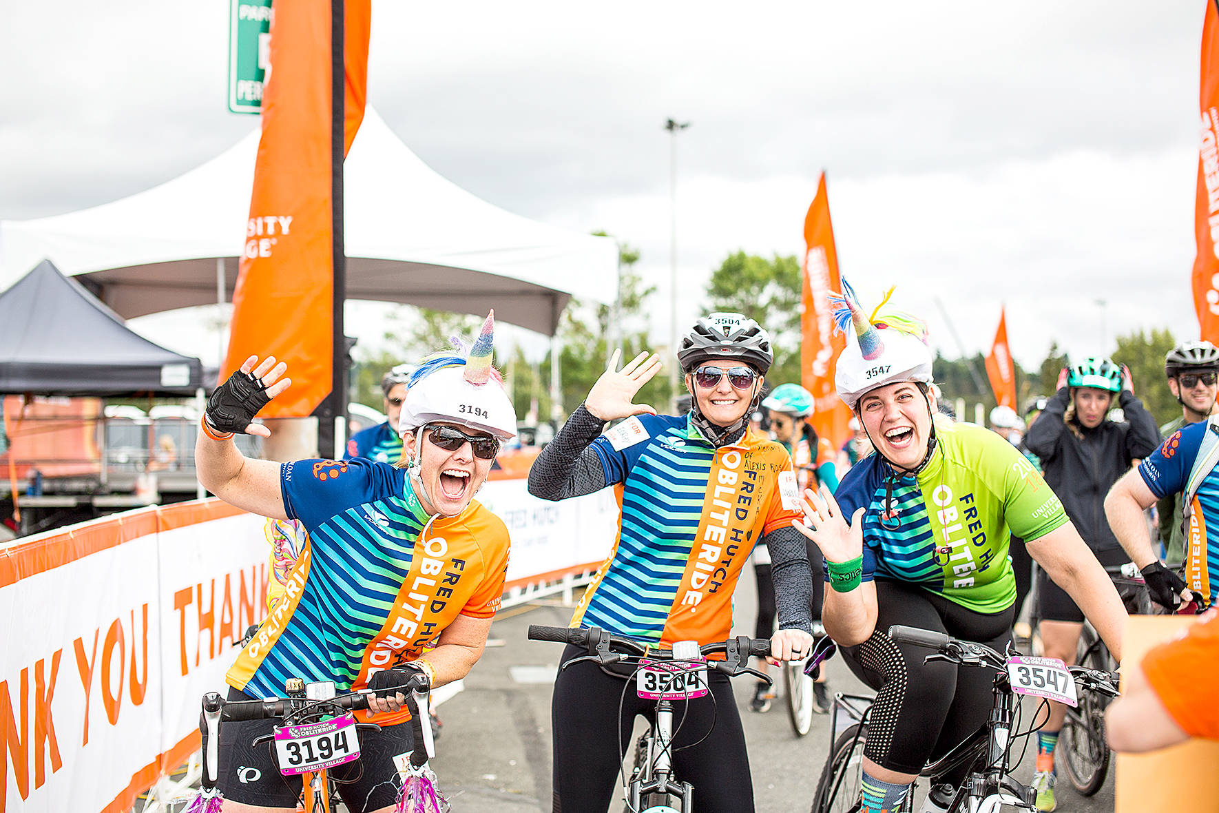Three friends and cyclists celebrate as they cross the finish line during the 2018 Obliteride event. Photo courtesy of Fred Hutch Obliteride.                                 Three friends and cyclists celebrate as they cross the finish line during the 2018 Obliteride event. Photo courtesy of Fred Hutch Obliteride.