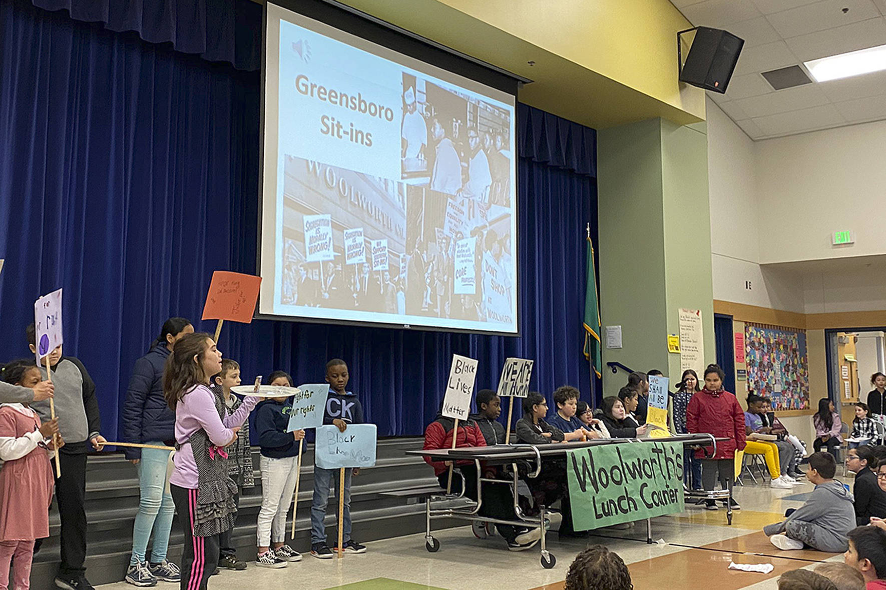Photos courtesy of Renton School District.                                Students across the district are hosting events, assemblies, celebrations of the life and work of Martin Luther King, Jr. Pictured are Benson Hill Elementary students reenacting lunch counter sit-ins and other Civil Rights actions against segregation. The district stated in a tweet that schools blend these activities into existing work to teach students history; Black scholars in math, science, medicine; segregation; race; and other topics of U.S. social and political climate.