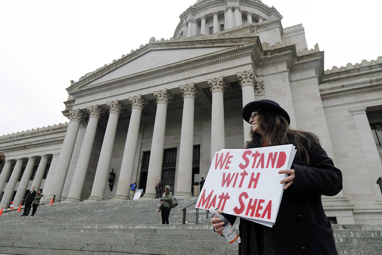 Petty Hutt of Gig Harbor holds a sign that reads “We Stand With Matt Shea,” as she attends a rally Jan. 13 at the Capitol in Olympia. (AP Photo/Ted S. Warren)