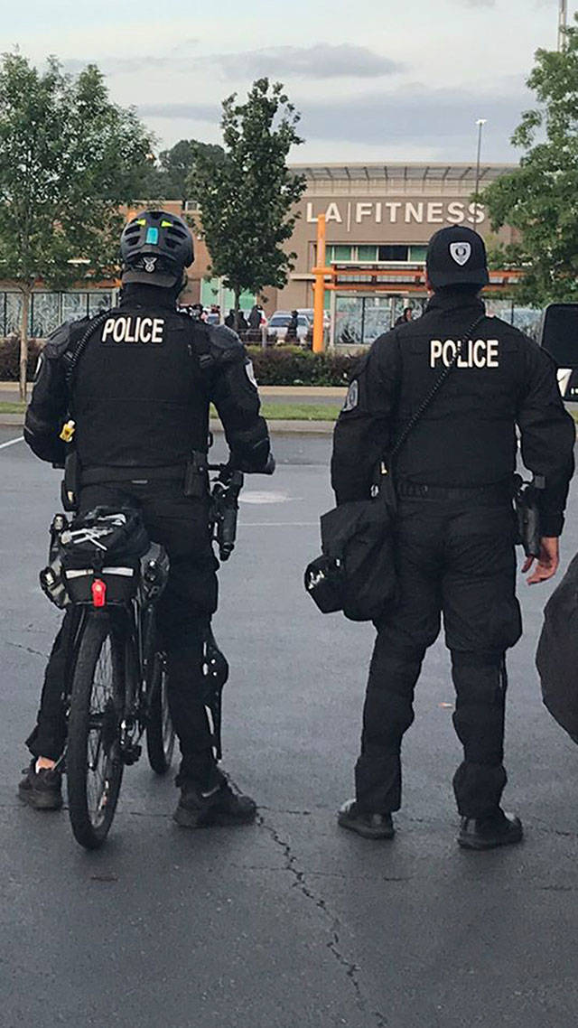 Officers keep watch on a large group that assembled Sunday night, May 31, near the LA Fitness in Tukwila. The group later began looting businesses. COURTESY PHOTO, Tukwila Police