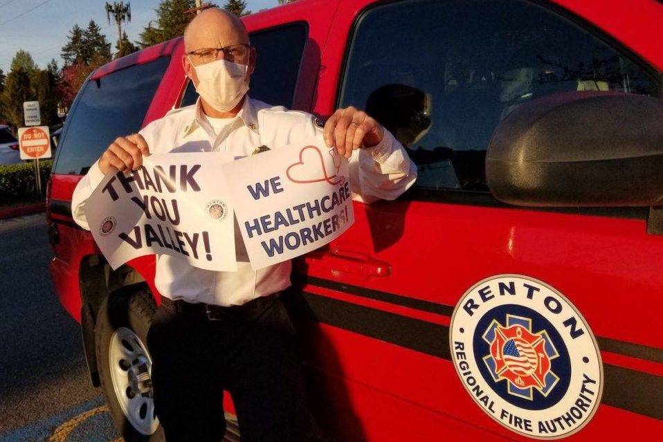 Fire Chief Rick Marshall holds signs of support during an April first responder’s “Thank You” parade for Valley Medical staff. Photo courtesy of RRFA.