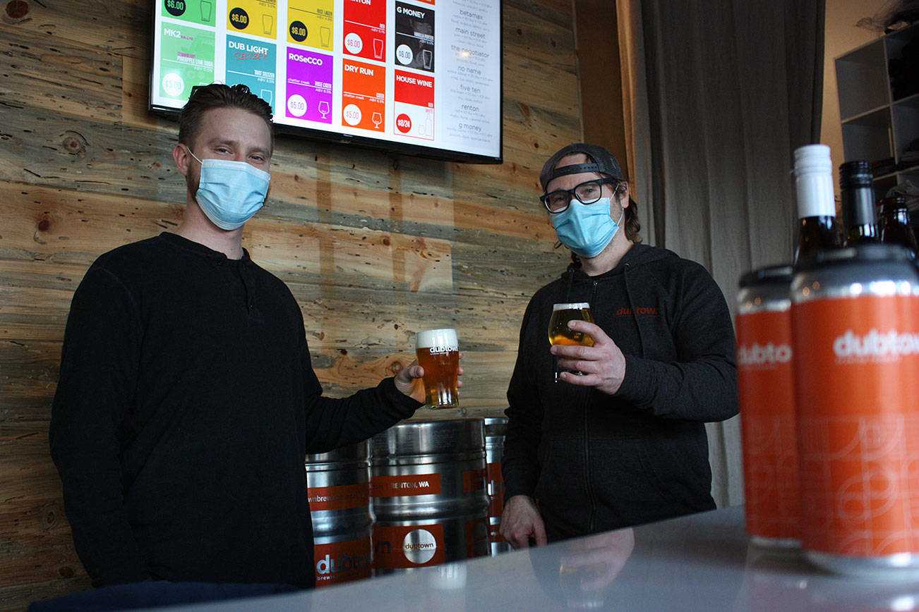 Beertender Nate Mak, left, toasts a fresh pint of beer with owner Jason Griggs. Photo by Cameron Sheppard/Renton Reporter