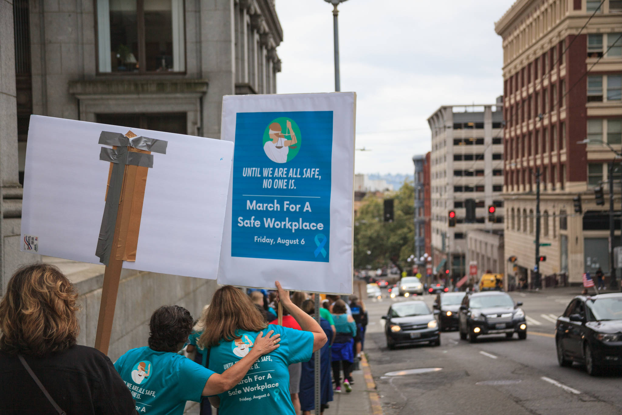 County employees and supporters walk around the block during a march for women’s safety at work in Seattle on Friday, Aug. 6, 2021. The march was scheduled after a woman was attacked in a bathroom at the King County Courthouse. Photo by Henry Stewart-Wood/Sound Publishing