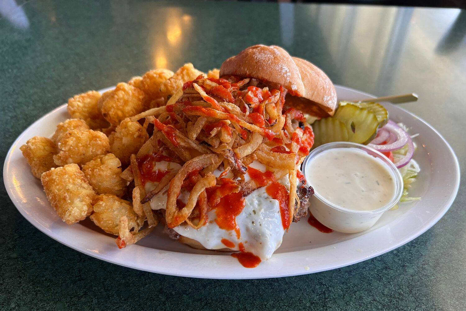 The Master Blaster Burger ($17.95) topped with pepper jack cheese, fried onions, a fried egg & drizzled with sriracha. Cameron Sheppard/ Renton Reporter