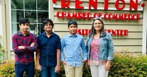 Courtesy photo. Tutum Hospitium founders Krithik, Dhruv and Ashwin stand outside the Renton Chamber of Commerce with Darlene Larsen.