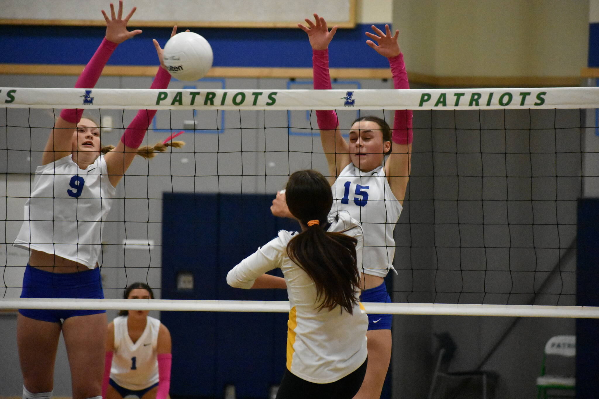 Maiya Lester (9) goes for a block with teammate Julianne Lee (15) against Bellevue. Ben Ray / The Reporter