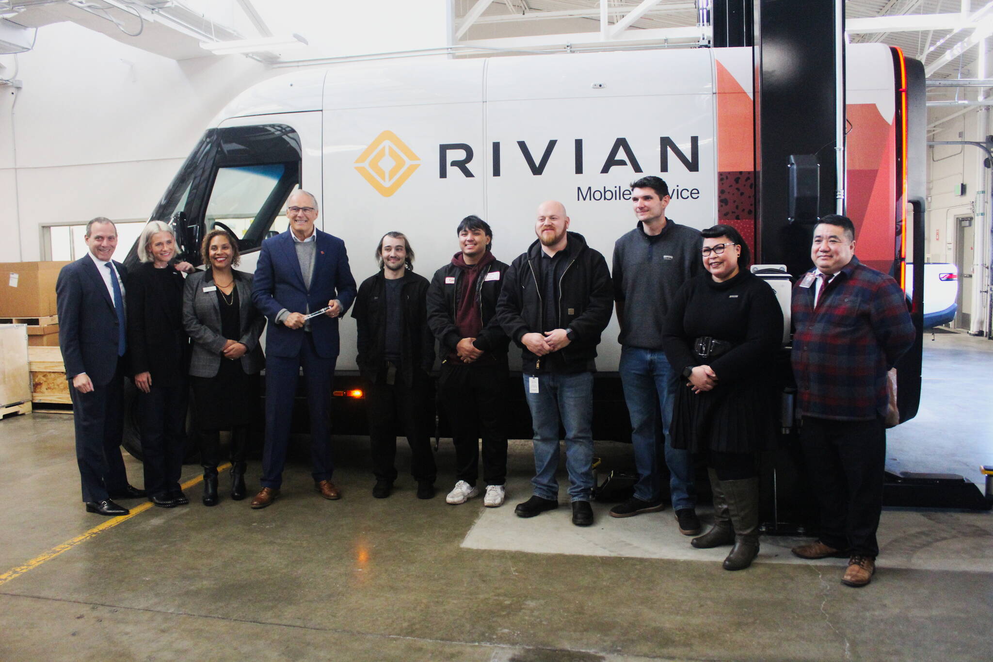 Gov. Jay Inslee, along with Rivian associates, RTC staff and RTC students in front of a Rivian mobile service vehicle after the governor toured the new program space. Photo by Bailey Jo Josie/Sound Publishing.