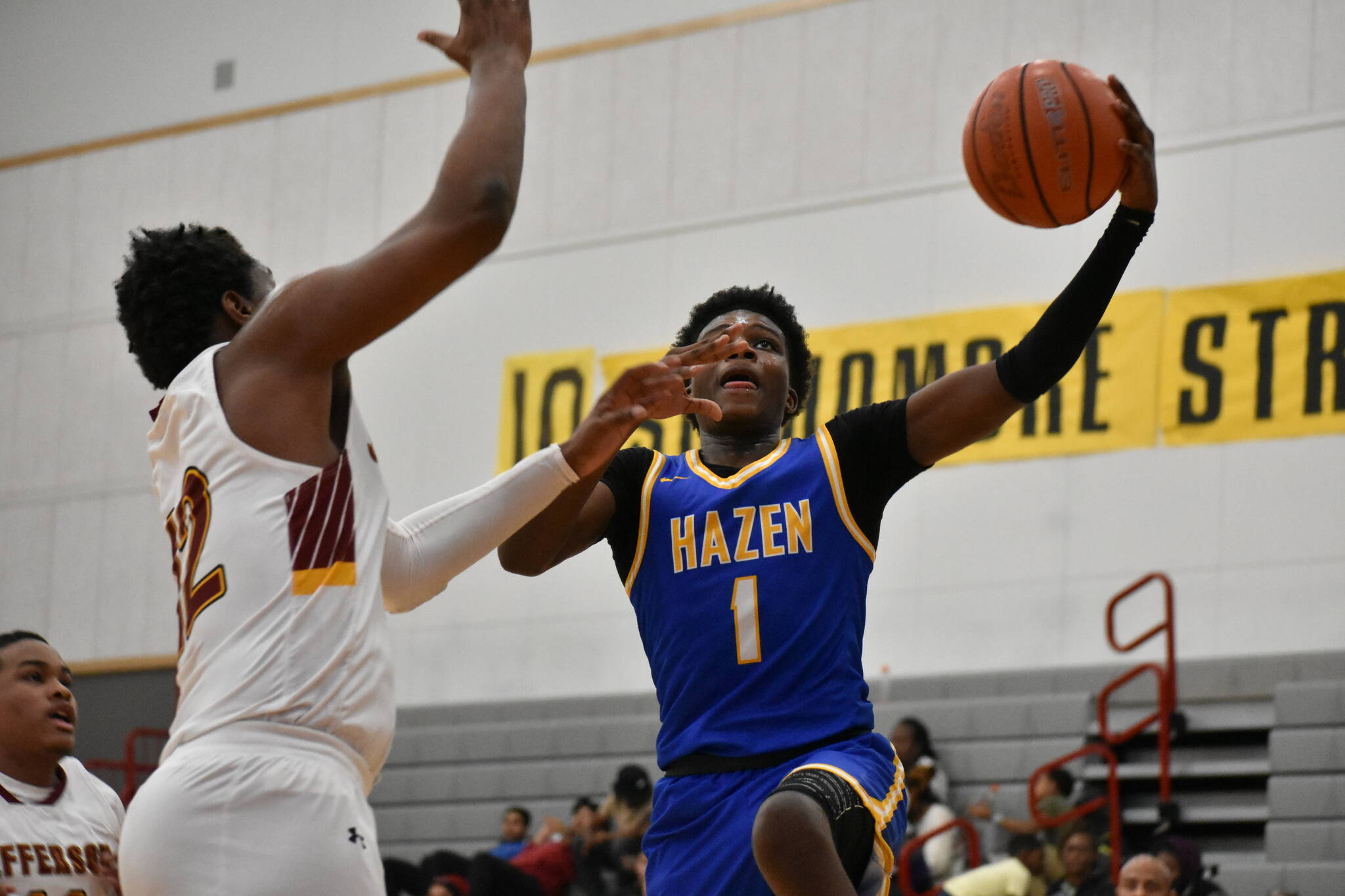 Hazen’s Jaiden Damus goes to the hoop with a defender in his face. (Ben Ray / The Reporter)