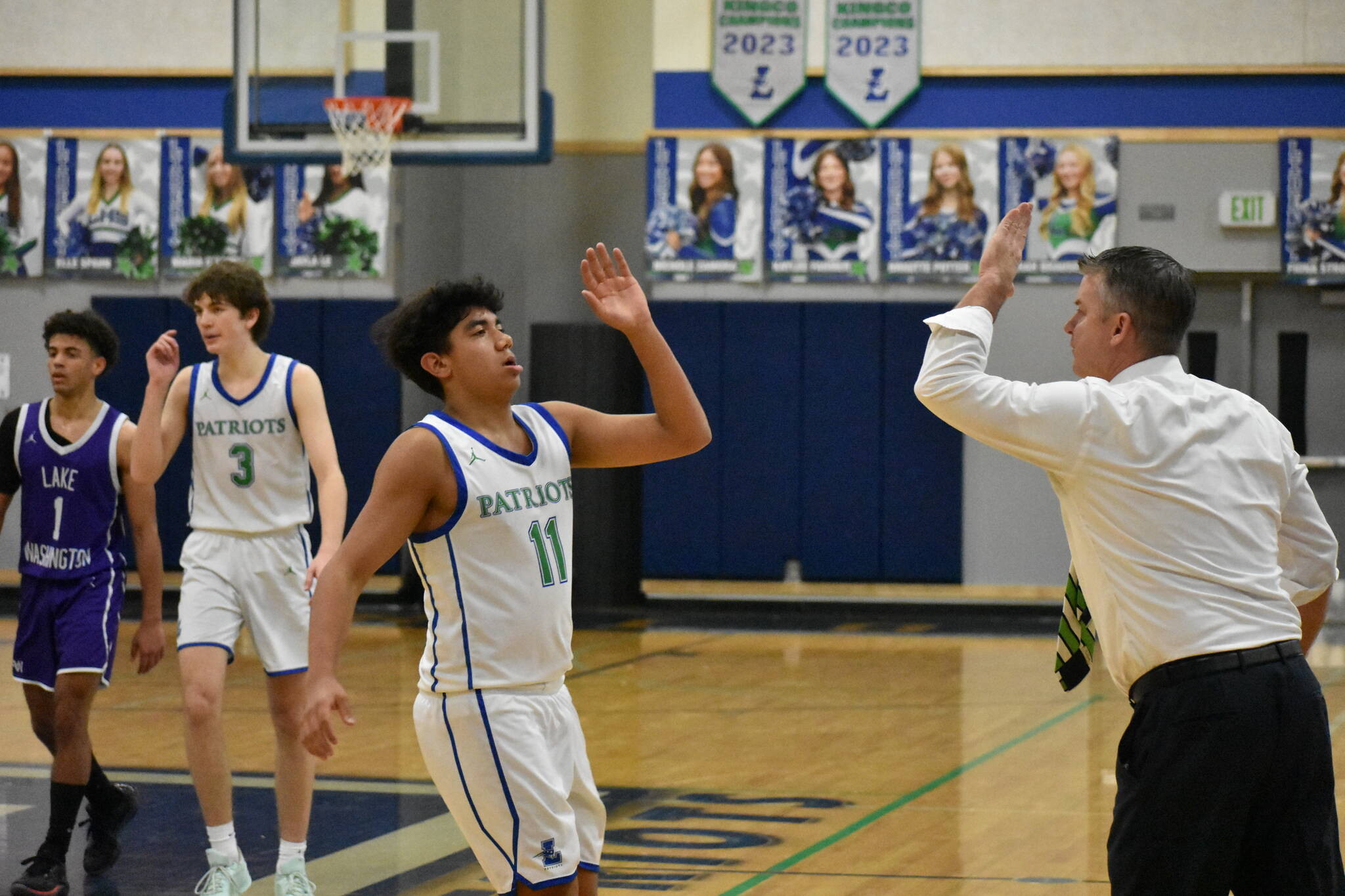 Tyson Burley and Head Coach Omar Parker high-five after a stop on defense. Ben Ray / The Reporter