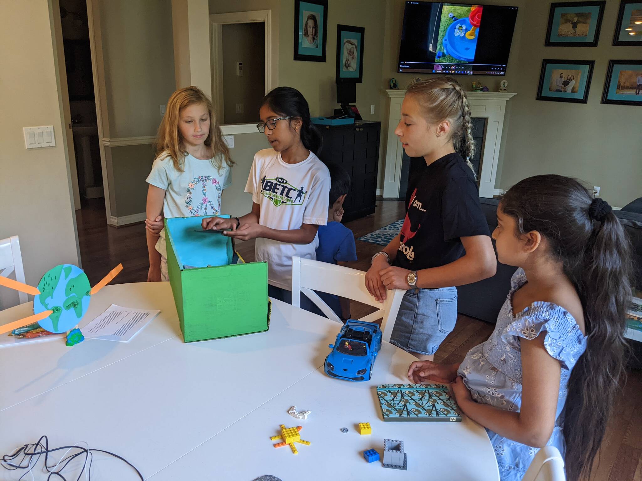 Photo courtesy of Julia Fishler
At the Kids Save The Earth event, Neha shows everyone the model for her litter-gathering robot. From left to right, Milla, Neha, Rohit, Callie and Dinaaz.