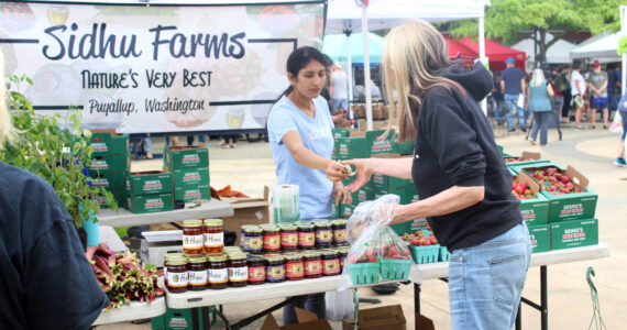 A customer buys strawberries from Sidhu Farms at the Renton Farmers Market. File photo
A customer buys strawberries from Sidhu Farms at the Renton Farmers Market. File photo