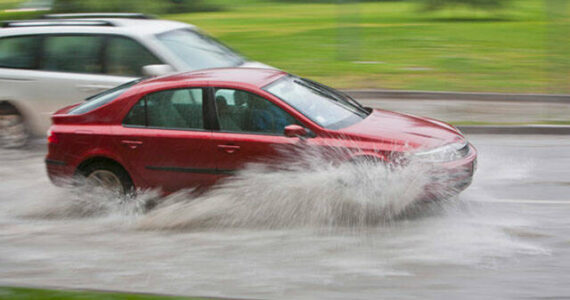 Vehicles passing through flooded street. File photo