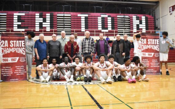 The current Renton team sits in front of the 1966-67 team, honored at halftime, and their championship banners. Ben Ray / The Reporter