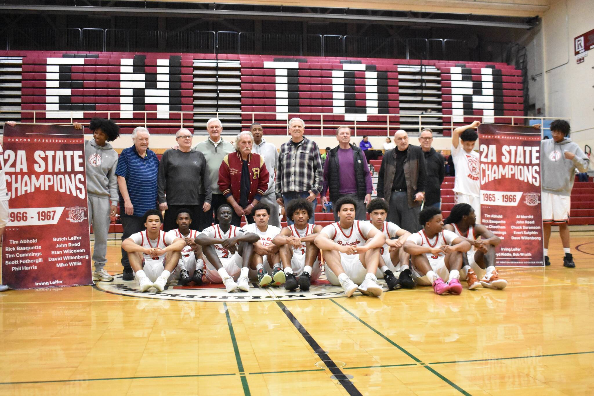 The current Renton team sits in front of the 1966-67 team, honored at halftime, and their championship banners. Ben Ray / The Reporter
