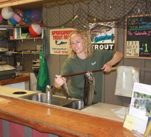 Springbrook Trout Farm Manager Tami Thueringer prepares three recently caught trout for some guests.