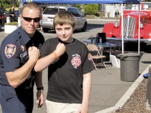 Renton firefighter and Fill the Boot coordinator Nathan Blakeslee stands with MDA client and Renton resident Cody Bedynek.