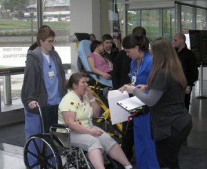 A ‘patient’ coughs repeatedly as she’s triaged outside the Emergency Department at Valley Medical Center in Renton Wednesday during a regionwide test of medical response to a terrorist attack.