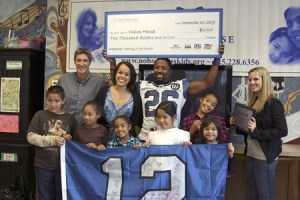Seahawks cornerback Josh Wilson holds a $2000 blown-up check for Vision House. On the top row from the left