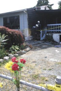 Investigators with the Renton Fire and Emergency Services Department prepare to enter a home in the Highlands Tuesday where a woman died the previous evening.
