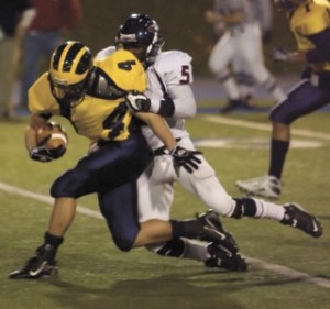 Lindbergh’s Frank Cange drags down Bellevue’s Sean Coley in the Wolverine’s 35-6 win Friday night.
