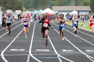 Shelly Sauls crosses the finish line during the 4x100 relay at the district meet this past weekend.