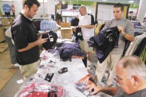 Golf Galaxy employees on Wednesday sort apparel as the store prepares for its November opening at its new location at The Landing. Pictured are Jason Denk