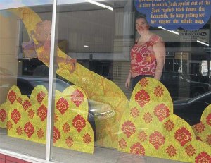 Tory Franklin peers out through the window of the former Renton Western Wear building that now contains her fairy tale-inspired art.