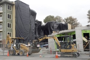 Crews will take another several days to finish cleaning up the remains of one of the buildings at the Harrington Square Apartments in the Highlands. The building was heavily damaged in a five-alarm fire on June 30. Black plastic protects the complex's second building