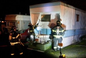 Renton Fire Engine 11 crew breaks out the front window of a mobile home that caught fire Saturday evening along Rainier Avenue.