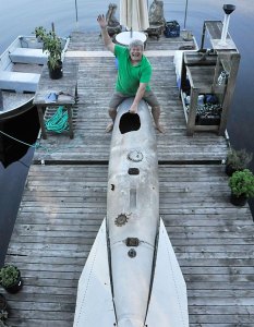 Keith Lanan poses for a photo at his Lake Kathleen home with the drop tank for a 1950s jet fighter that he fished from the lake.