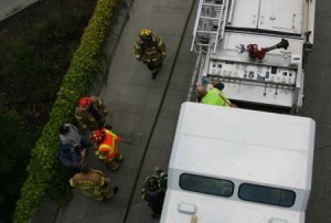 A firefighter wears his mask after walking away from a hydrochloric acid spill on I-405 southbound Friday afternoon. It took emergency responders about an hour and a half to clean up the mess.
