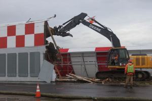 Workers tear down the old blast fence at Renton Municipal Airport.