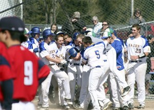 Hazen players celebrate with Zac Kolterman after Kolterman's walk-off home run against Kennedy Catholic April 14.