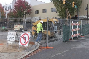 Workers replace pedestrian pavers on a closed Burnett Avenue downtown.