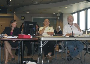 David Keyes (right) and Paul Ouellette (center) make their case before a hearing examiner for an appeal they filed to the downtown Renton library renovation project. City Planner Vanessa Dolbee looks on.