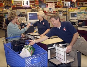 Long-time customer Arlis Peterson is helped checking out Tuesday at the Renton IGA on Southeast 128th Street east of Renton from owners Pam and John Lowney. The store is going to close within a matter of days
