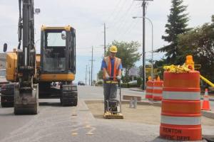 City workers install a pedestrian island on Northeast Fourth Street near Queen Avenue.