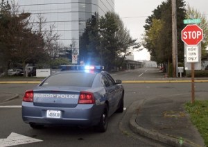 A suspect in a residential burglary in the Highlands awaits transport inside this Renton Police patrol car about noon Thursday at Wells Avenue North and North Sixth Street.
