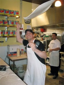 Smoking Monkey Pizza pizzaiolo Gustavo Frias tosses a pizza into the air as he prepares another pizza at the new downtown Renton pizzeria. The new restaurant will feature regional Italian pizzas.